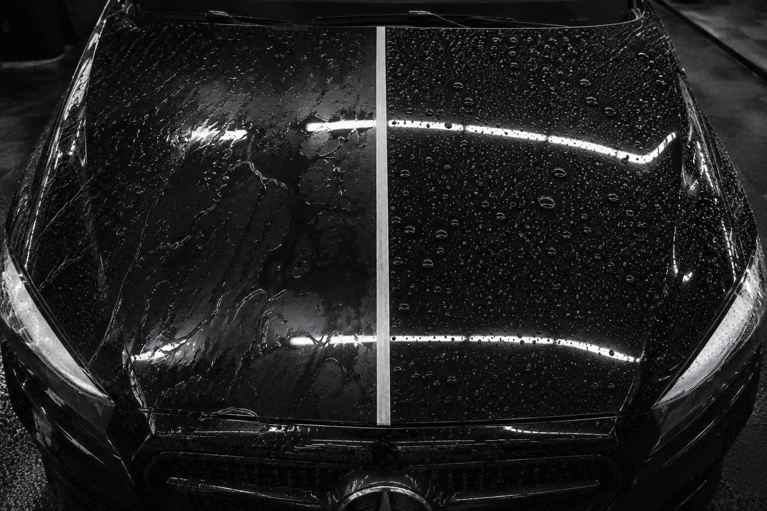 Water beads flattening and spreading on a dark painted panel